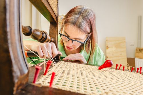 Ein Möbelflechterin beim Einflechten eines "Wiener Geflechts" © wienwork/Luiza Puiu Ein Möbelflechterin beim Einflechten eines "Wiener Geflechts" © wienwork/Luiza Puiu